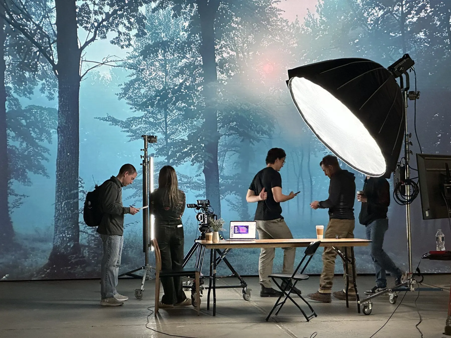 Film crew shooting in front of a forest LED wall