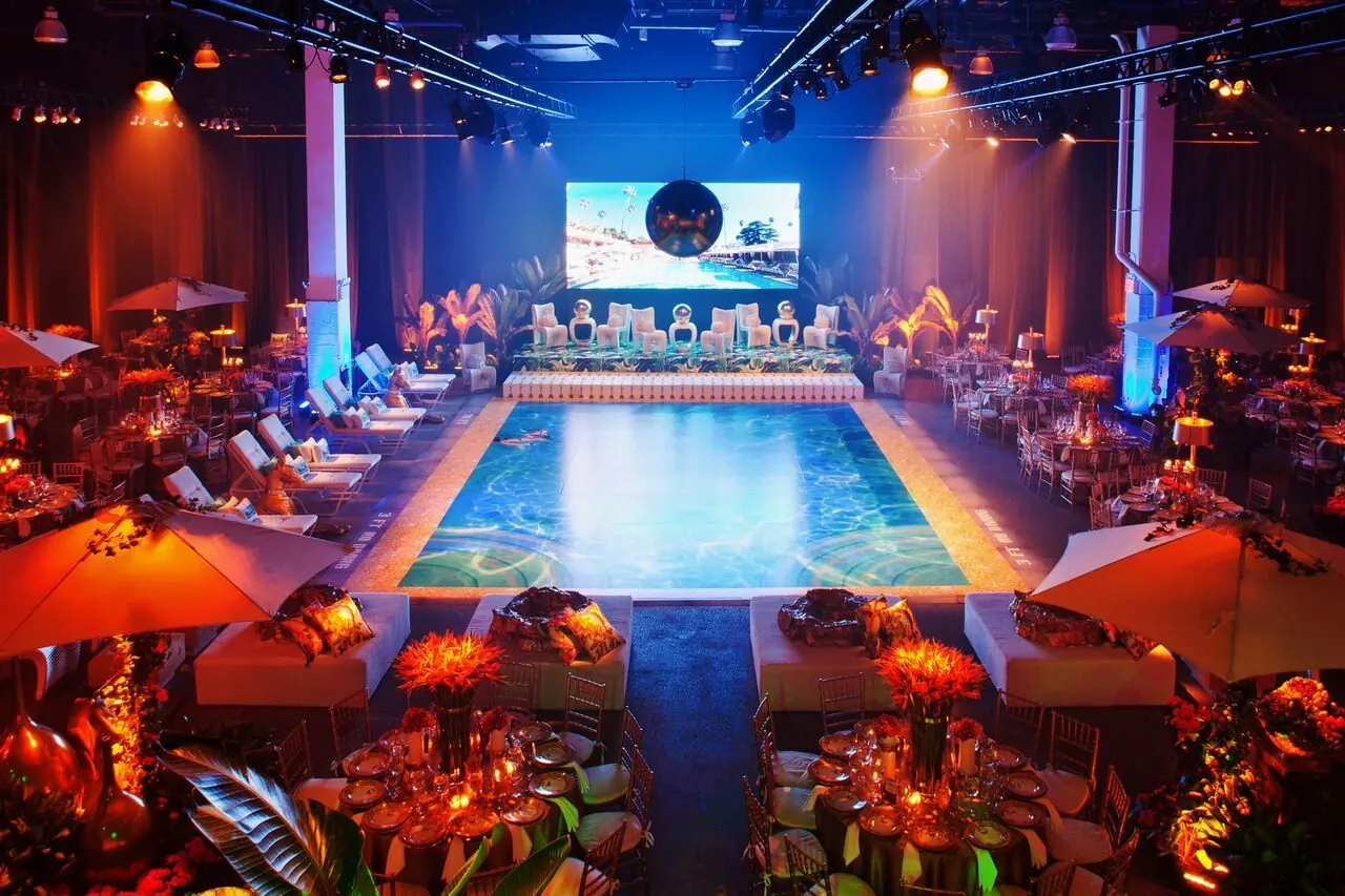 A poolside-themed gala at Stage 37 with a lit pool runway, cabanas, palms and an LED screen, produced by CMG Event Group
