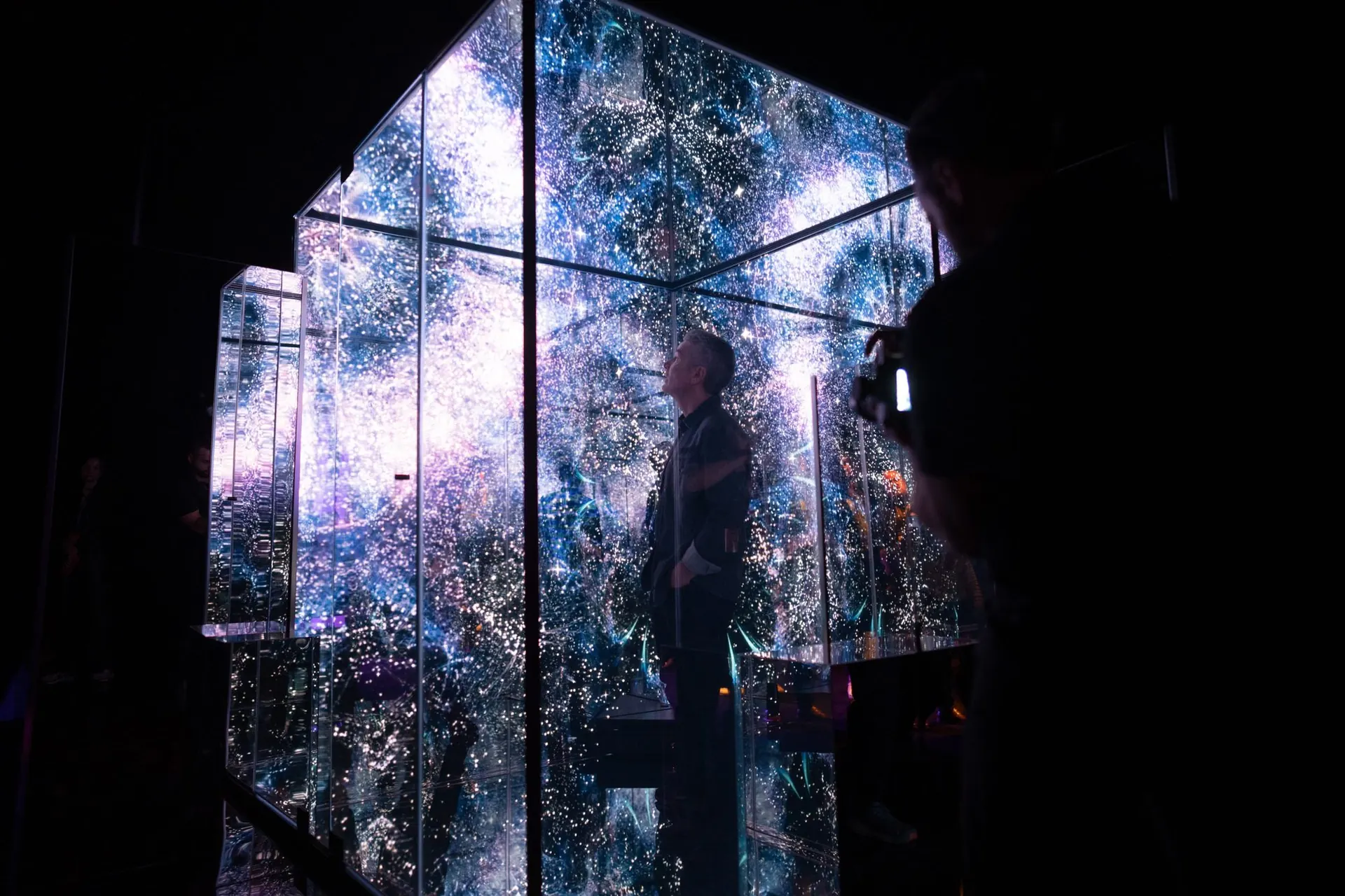A guest inside a custom-built mirrored LED cube installation