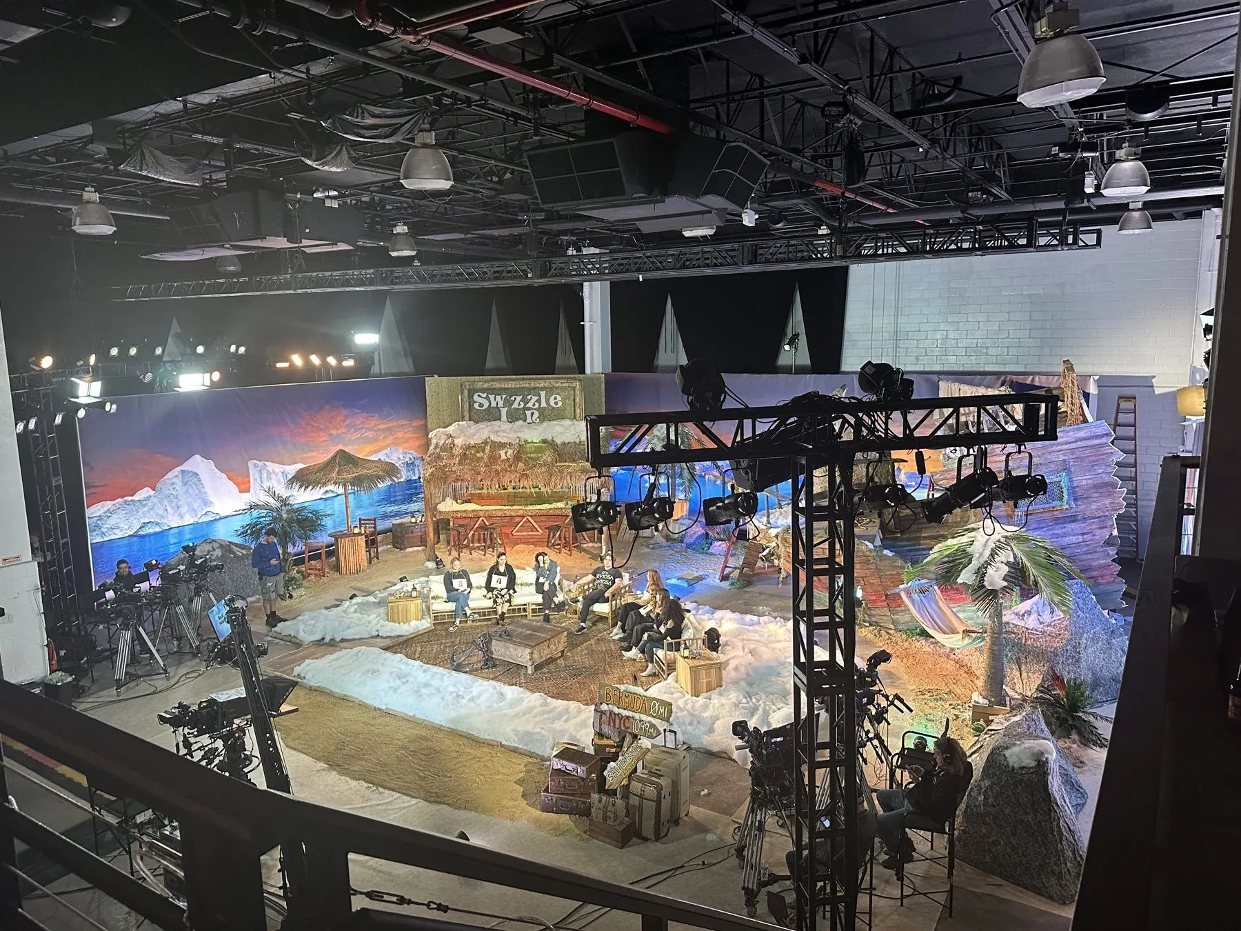 A full beach-bar television set built on the main floor, cameras in place