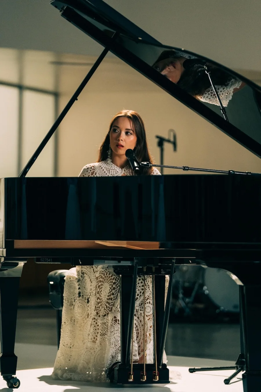 Laufey performing at a grand piano inside the Guggenheim Museum